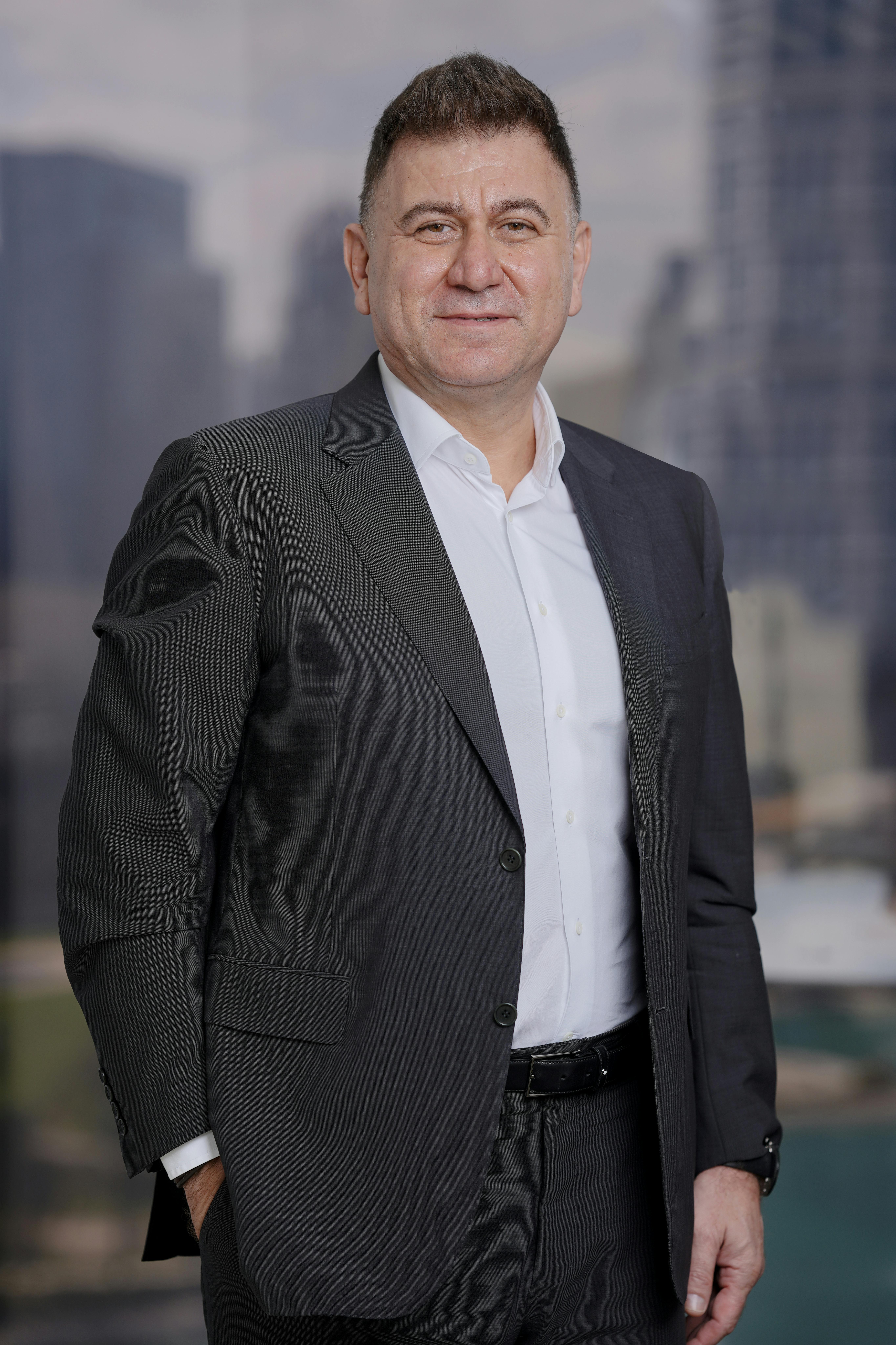 Portrait of a confident businessman in a suit with city skyscrapers in the background.