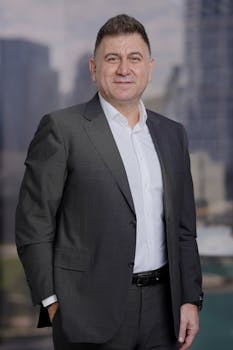 Portrait of a confident businessman in a suit with city skyscrapers in the background.