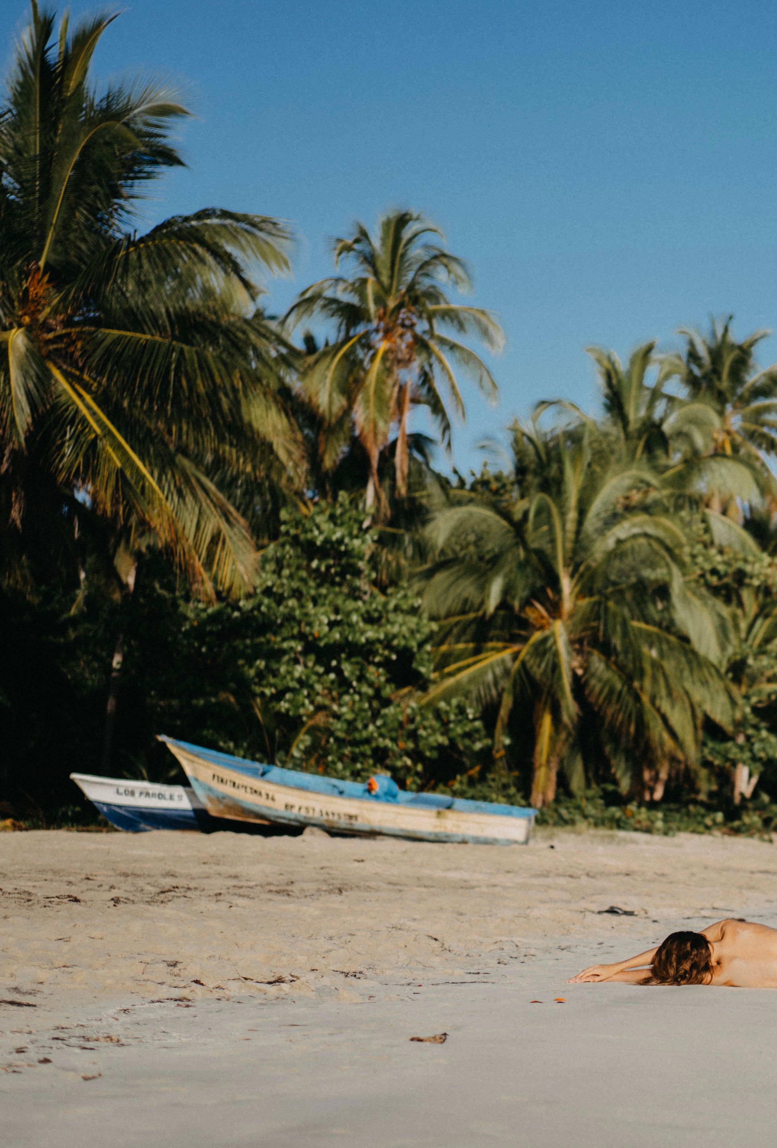 Relaxing tropical beach view with palm trees and boats in Las Terrenas, Dominican Republic.