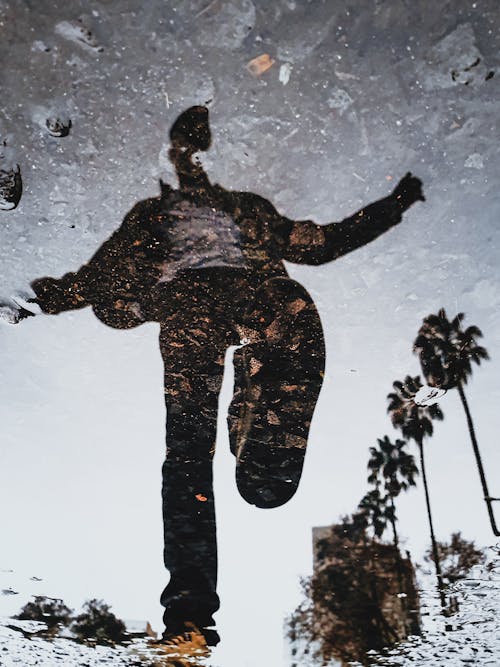 Reflection of Man About to Step on Pool of Water