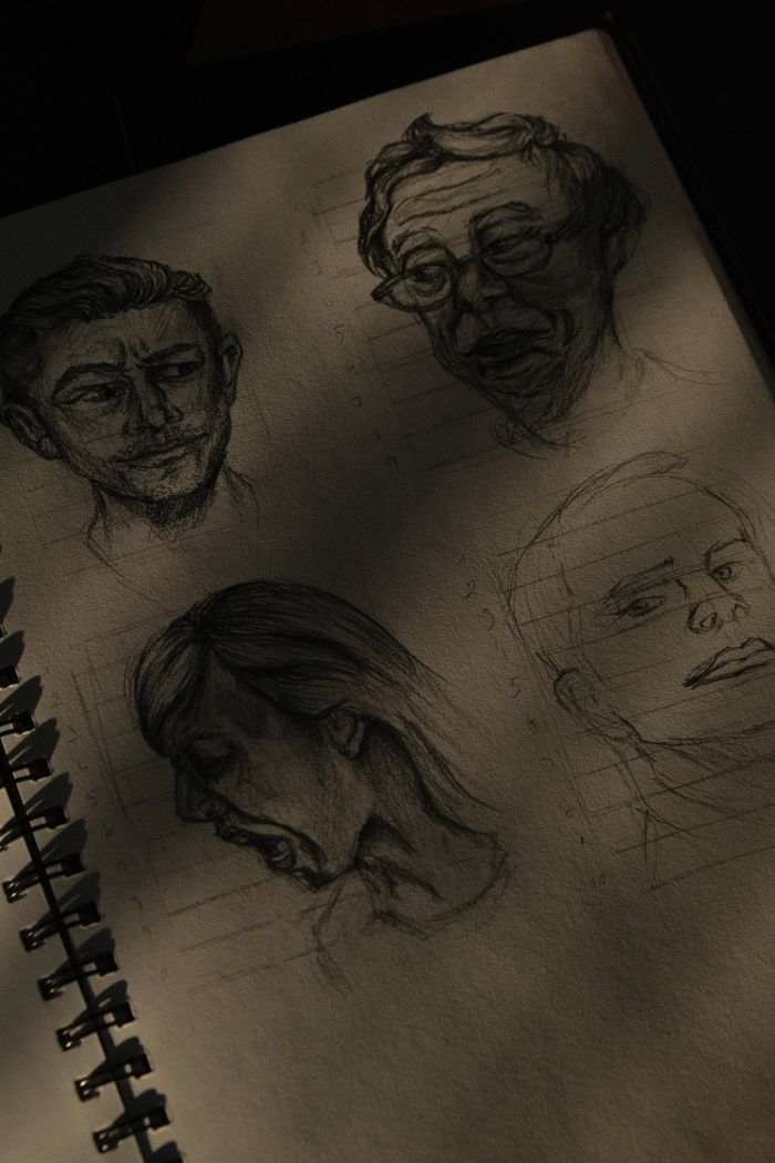 Pencil portrait sketches on a sketchbook page without hands