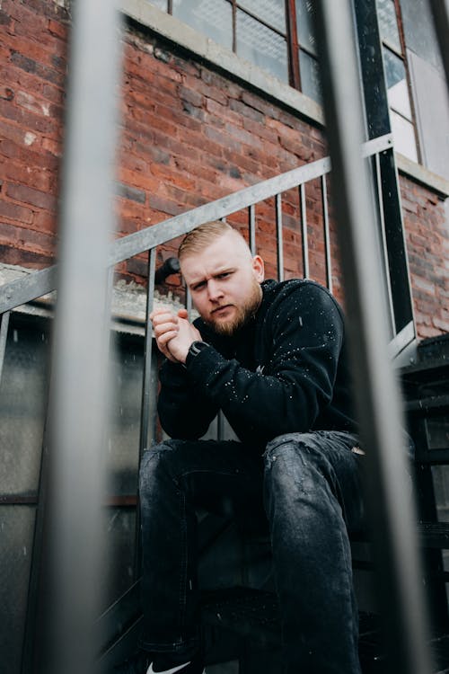 Low-Angle Photo of Man Sitting on Staircase