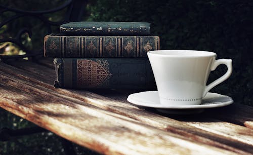 Foto Van Keramische Kop En Schotel Naast Een Stapel Boeken Op Houten Parkbank