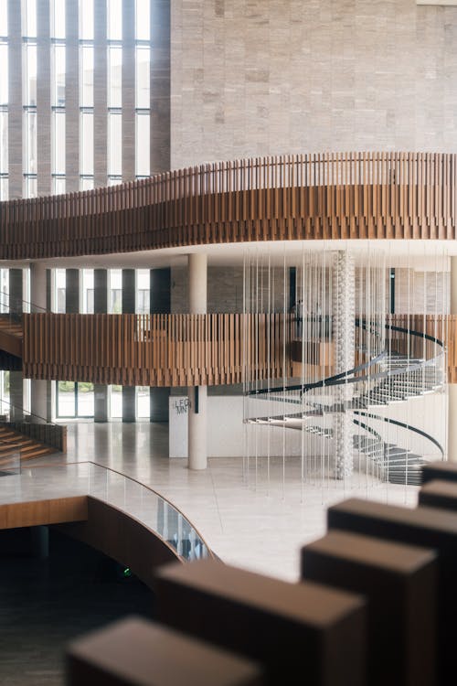 Free A modern building with a spiral staircase and wooden floor Stock Photo