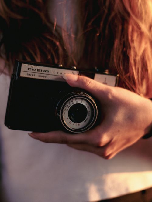 Free A close-up view of a woman's hand holding a vintage analogue camera. Stock Photo