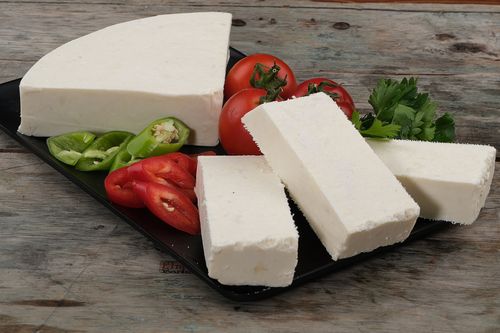 Free A delicious arrangement of cottage cheese, fresh tomatoes, and peppers on a rustic wooden surface. Stock Photo