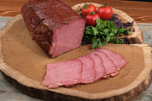Free Delicious sliced roast beef with fresh parsley and tomatoes on a rustic wooden platter. Stock Photo