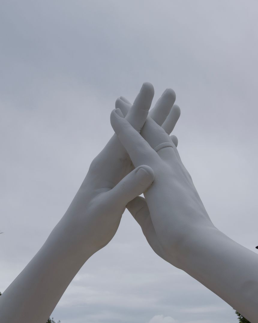 Marble sculpture of interlocking hands reaching upward — Leonardo Caporali on Pexels