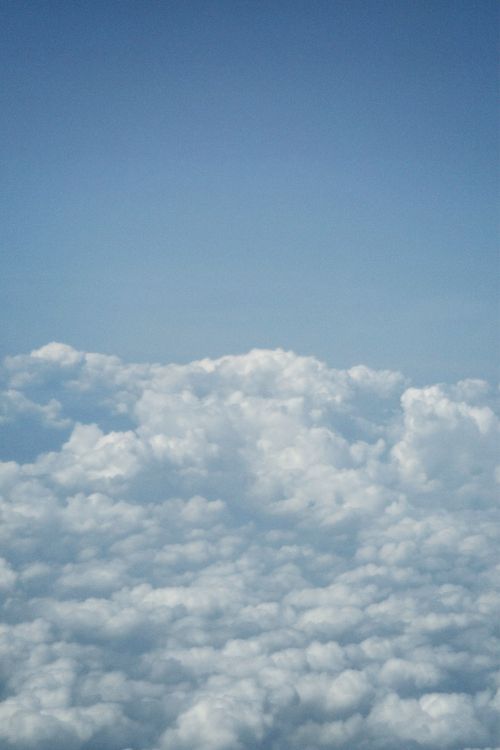 Free Vast expanse of fluffy white clouds against a clear blue sky, depicting tranquility above Milan, Italy. Stock Photo
