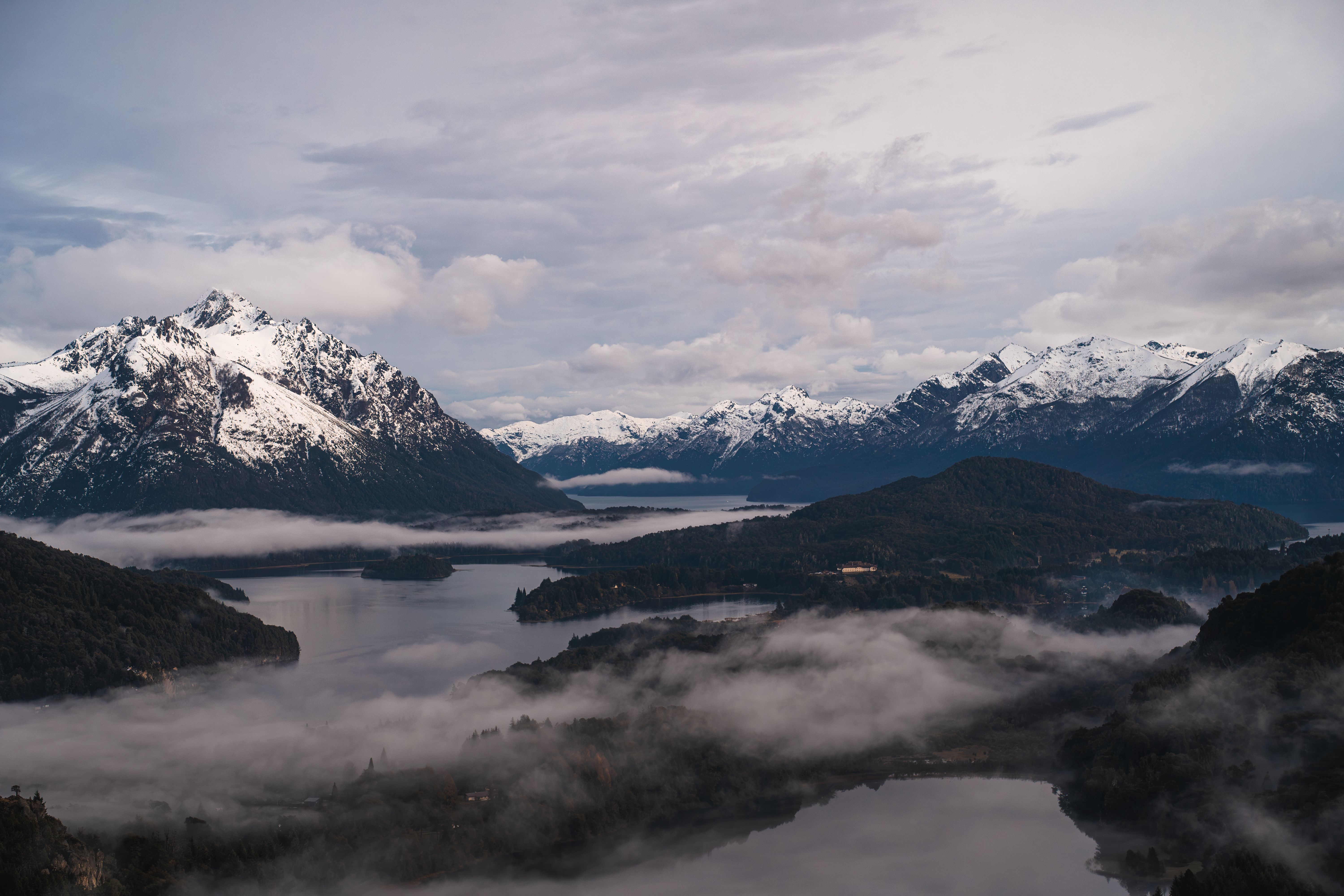Stunning winter landscape of Bariloche with snowcapped mountains and misty lakes.