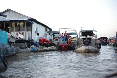 Free Experience the bustling life of Cần Thơ's floating market with boats and locals trading goods. Stock Photo