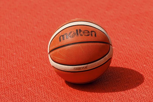 Close-up of a Molten basketball on a red textured outdoor court, ideal for sports-related designs.