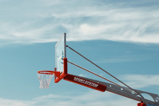 A basketball hoop with a transparent backboard set against a clear blue sky in Saulkrasti, Latvia.