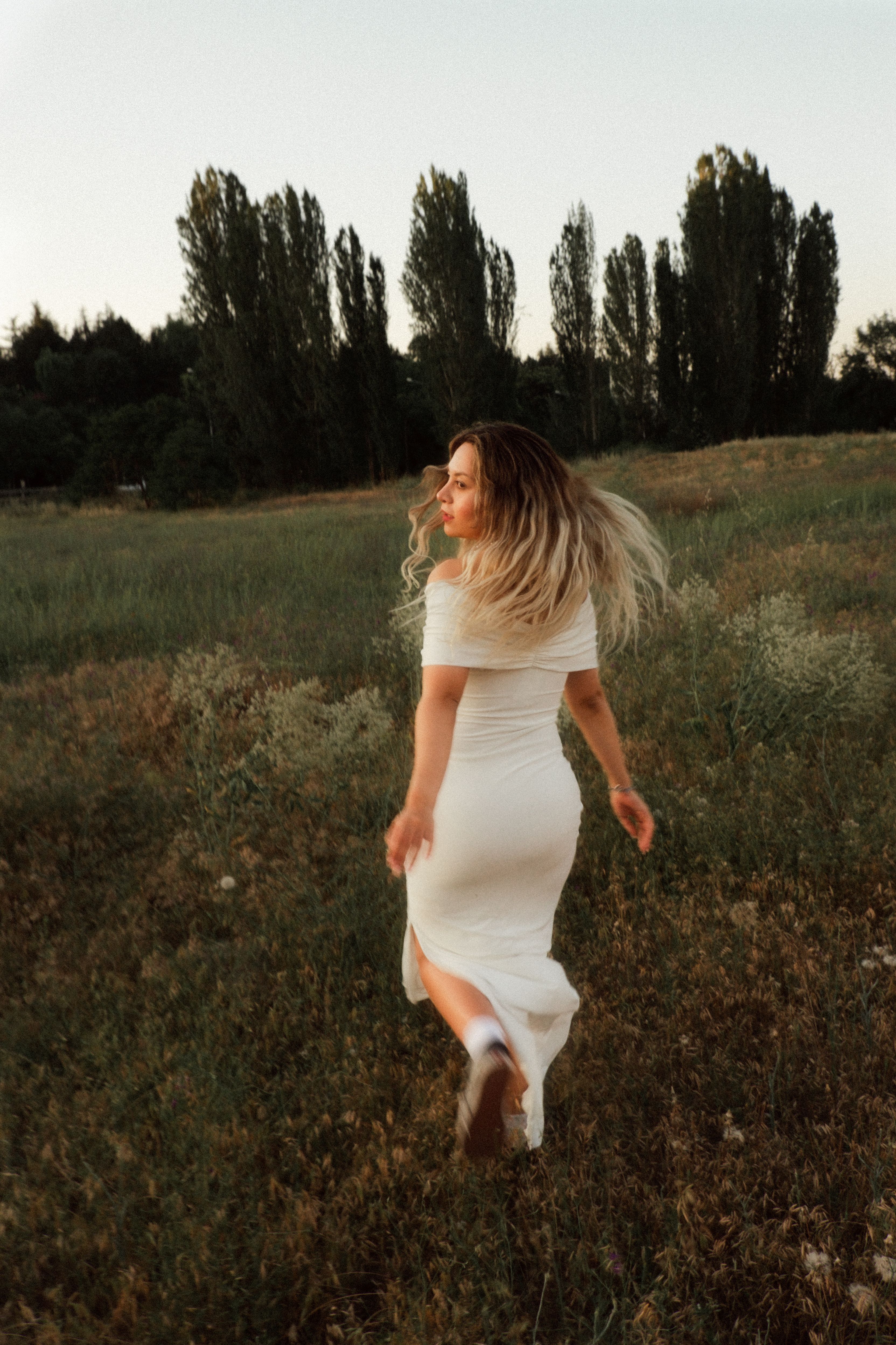 A Woman in White Dress Walking on Green Grass Field · Free Stock Photo
