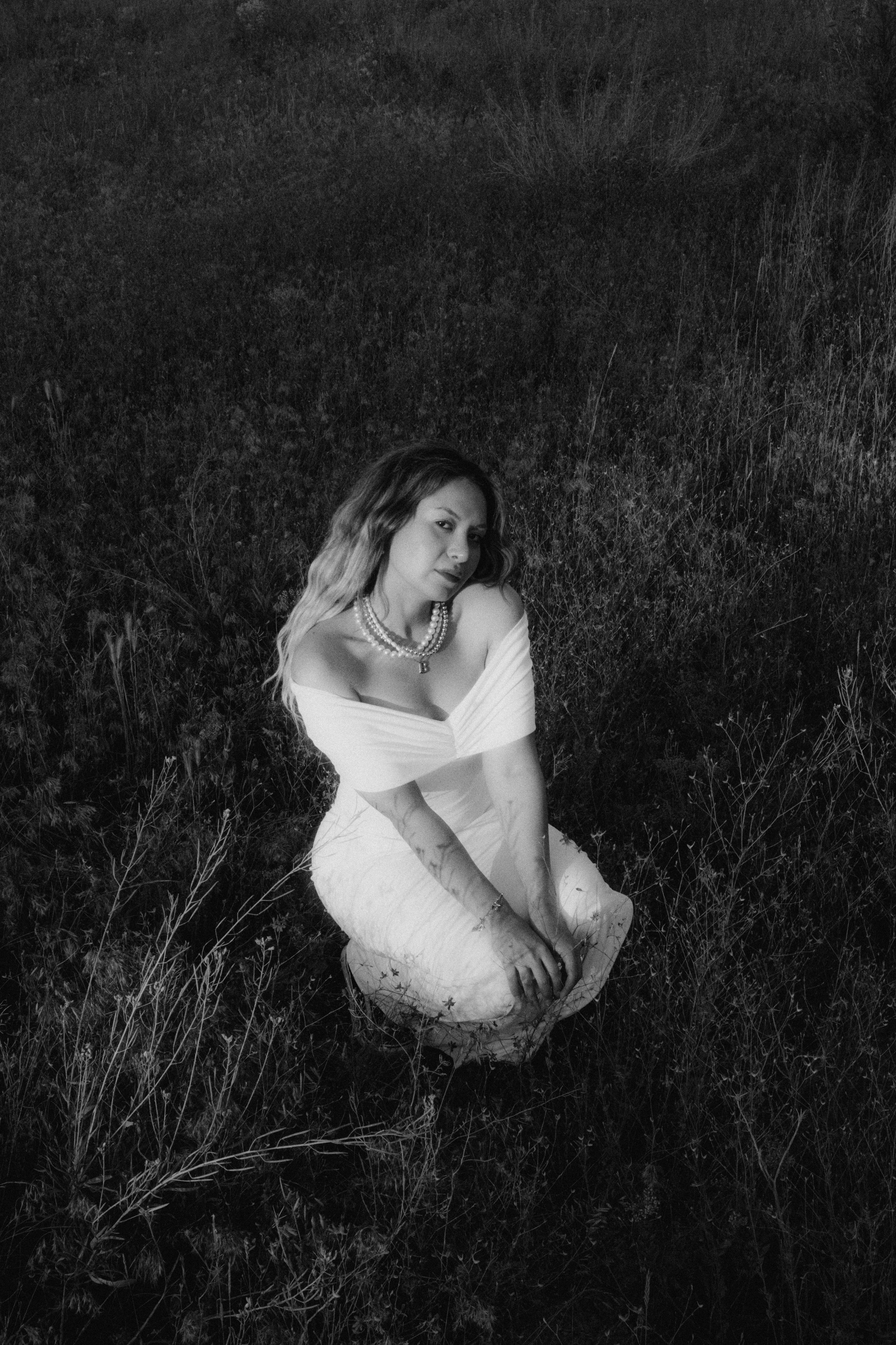 A woman in a white dress sitting in the grass · Free Stock Photo
