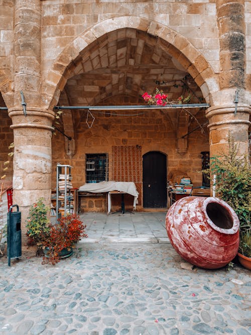 A red pot sits on a stone wall in an old building