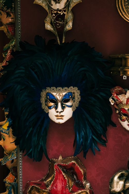 Free Detailed close-up of a Venetian mask with ornate feathers in a display setting. Stock Photo