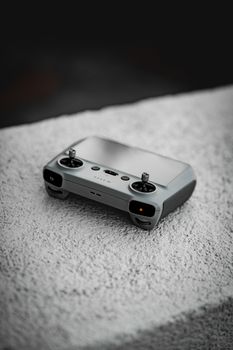 Close-up shot of a drone remote controller on a textured surface, highlighting advanced technology.