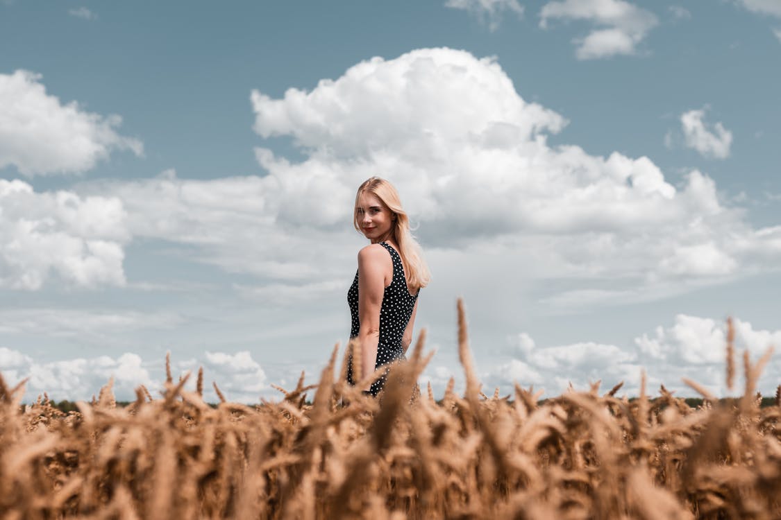 Free Woman Standing on Grass Field Stock Photo