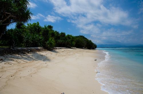 Free Discover a serene tropical beach with pristine sand and clear blue waters, perfect for relaxation. Stock Photo