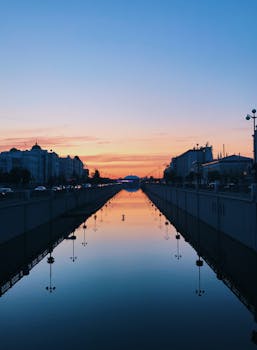 运河上，迷人的日落倒映在平静的海水中，勾勒出城市景观的轮廓