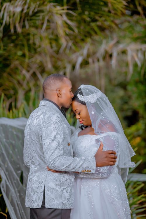 Free A beautiful portrait of newlyweds sharing an intimate moment outdoors. Stock Photo