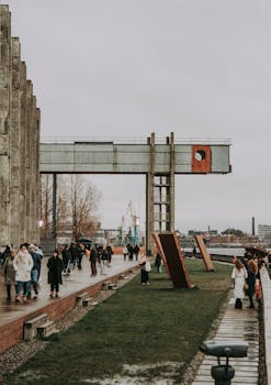 People strolling on a promenade at Sevkabel Port, Saint Petersburg, Russia on a cloudy day.