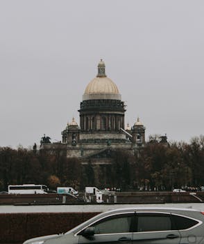 View of St. Isaac's Cathedral in Saint Petersburg on a cloudy day, featuring classic architecture and iconic dome.