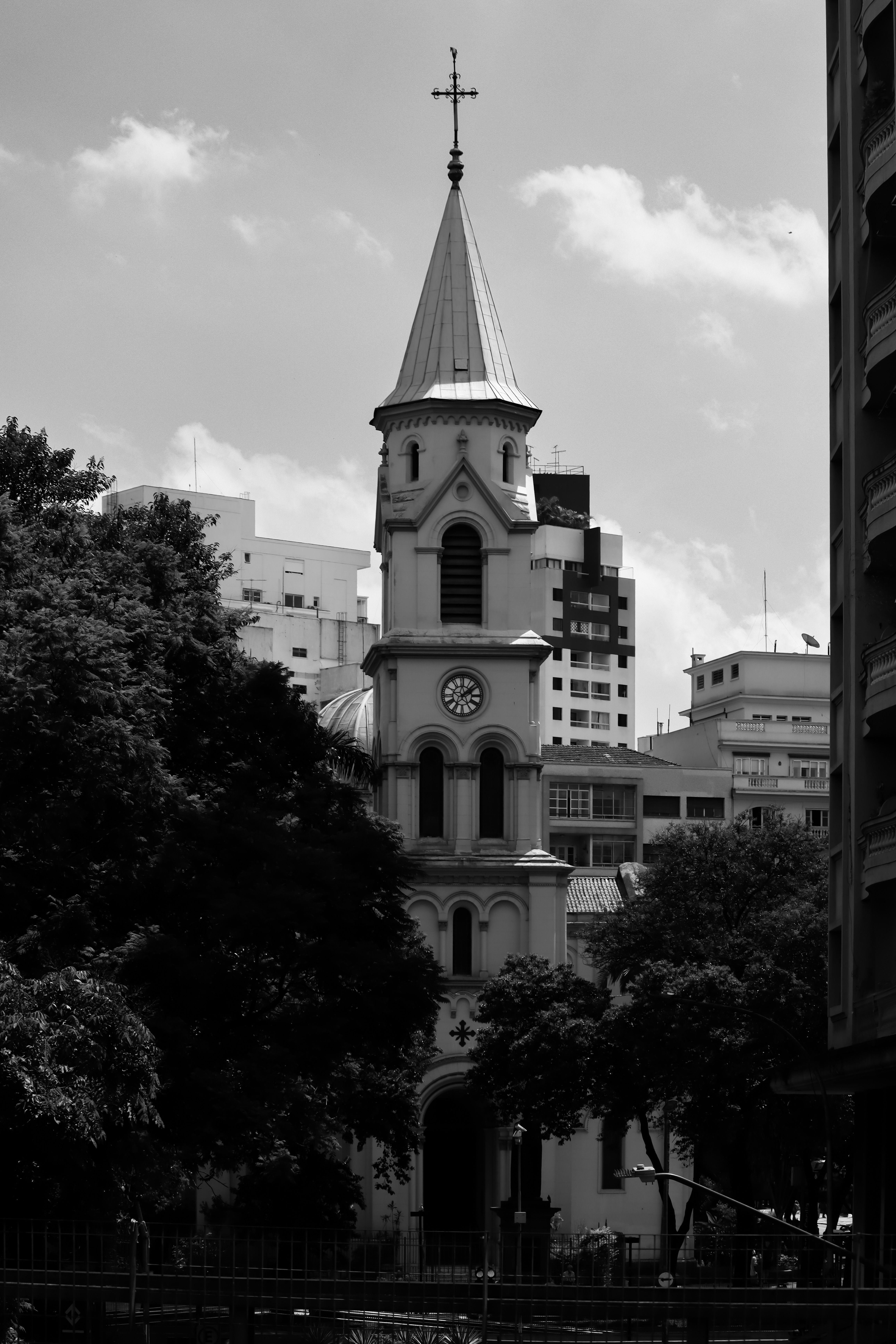 Black and white photo of Santa Cecilia Church amidst Sao Paulo buildings, highlighting its architectural beauty.