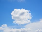 夏日的天空清澈，明亮的白色积云映衬在生动的蓝色背景上