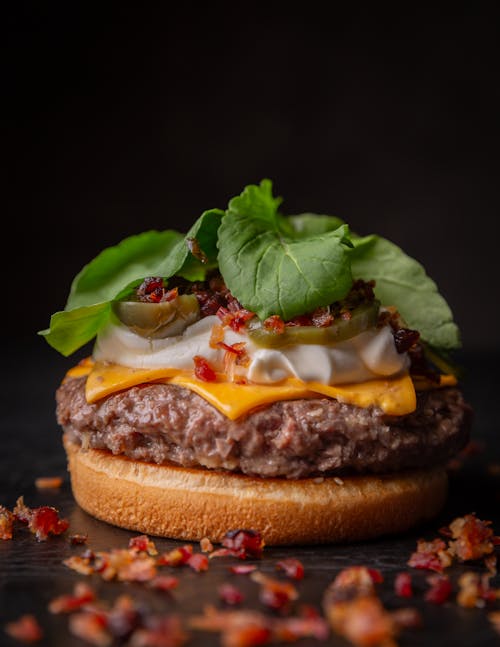 Free A burger with bacon, cheese and lettuce on top Stock Photo