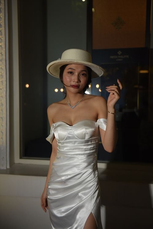Free Young woman modeling a stylish white dress and hat indoors, exuding elegance and fashion. Stock Photo