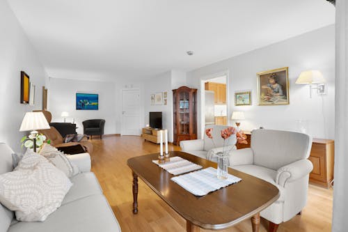 A living room with hardwood floors and white furniture