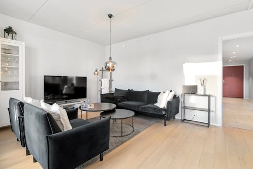 A living room with black furniture and a tv