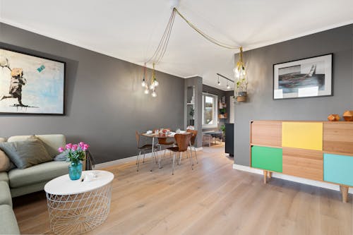 A living room with a wooden floor and a gray couch