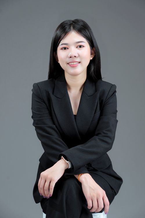 Free Confident Asian businesswoman smiling in a studio portrait, wearing a stylish black suit. Stock Photo