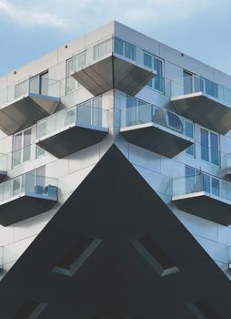 A contemporary apartment building with unique balconies and modern architecture in an urban setting.