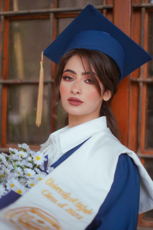 Free A proud woman in graduation attire, showcasing achievement and elegance. Stock Photo