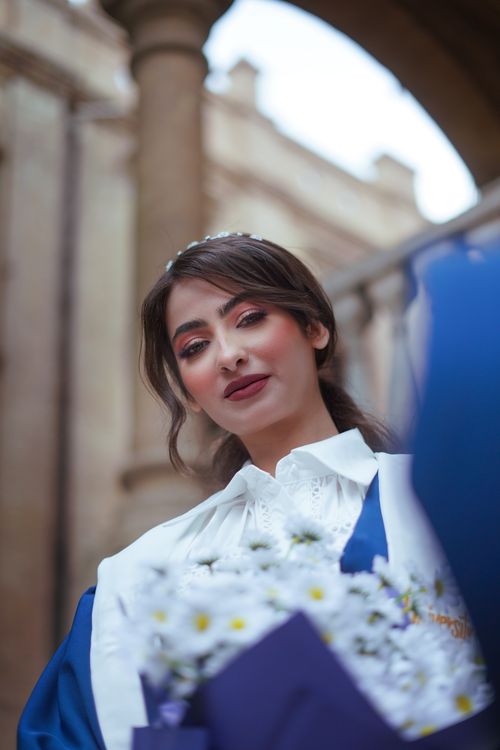 Free Graduation portrait of a woman holding a floral bouquet in Baghdad, Iraq. Stock Photo