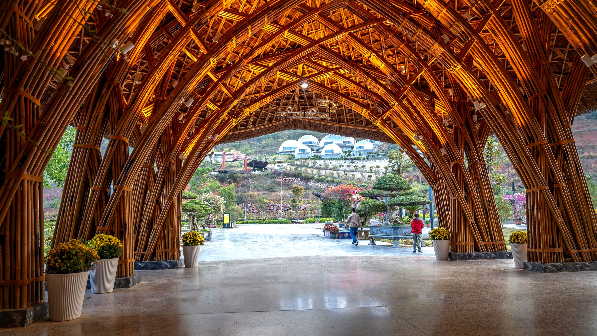 Stunning bamboo archway at a luxury resort in Vietnam with a view of the surrounding landscape.
