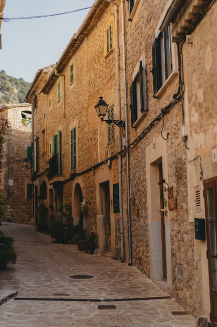 Picturesque cobblestone street in Valldemossa, Spain, showcasing traditional stone houses.