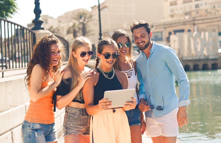 Group Of People Standing Beside Body Of Water