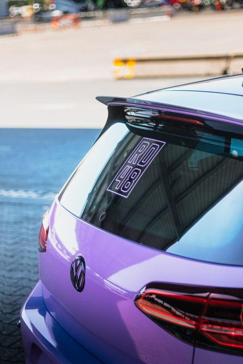 Free Close-up view of a purple Volkswagen car with a rear windshield sticker in an urban setting. Stock Photo