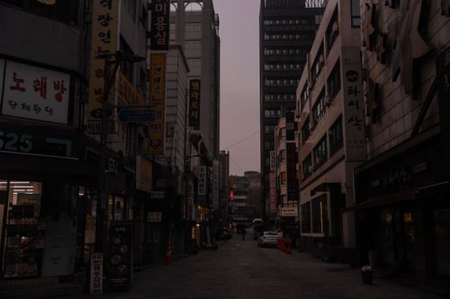 Free Dimly lit urban alley lined with tall buildings in Seoul, exuding a moody vibe. Stock Photo