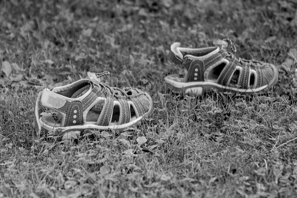 бесплатная Пара серых сандалий для малышей на траве Стоковое фото