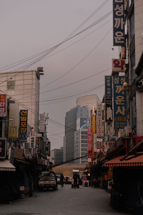 Free Urban street scene with Korean signage and modern buildings, capturing daily city life. Stock Photo