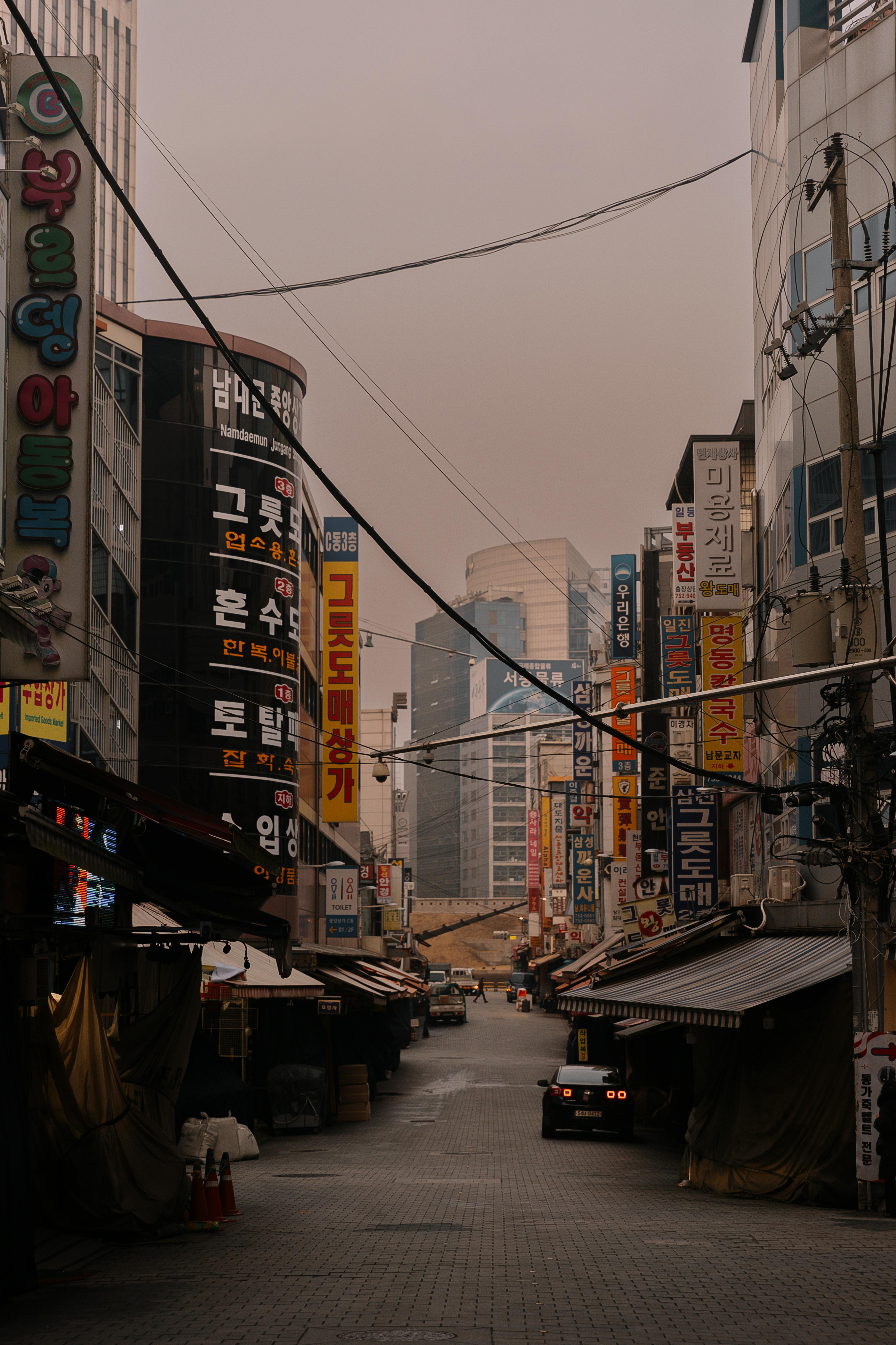 A vibrant urban street scene in an Asian city, filled with colorful advertisements and city life.