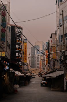 A vibrant urban street scene in an Asian city, filled with colorful advertisements and city life.