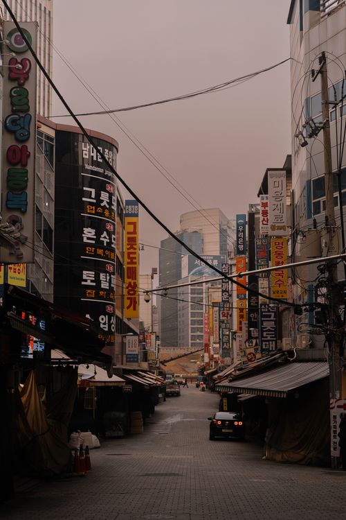 Free A vibrant urban street scene in an Asian city, filled with colorful advertisements and city life. Stock Photo
