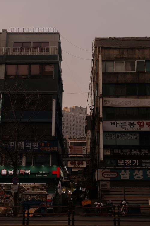 Free Moody street scene showcasing narrow alleyways and tall urban buildings at dusk. Stock Photo